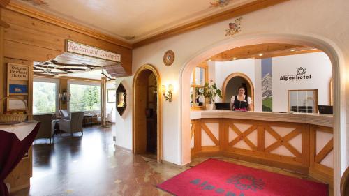 a woman standing at a counter in a salon at Alpenhotel Oberstdorf - ein Rovell Hotel in Oberstdorf
