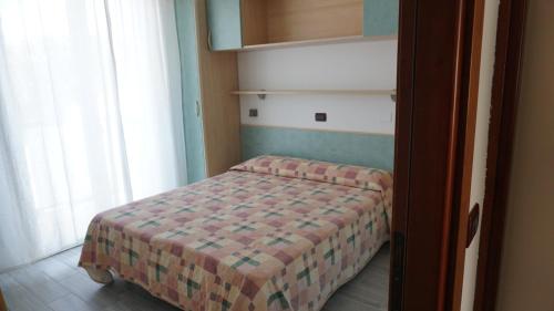 una piccola camera con un letto in una stanza di Residence Renadoro a Cervia