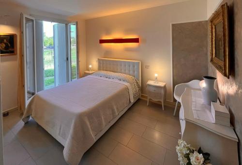 a bedroom with a large bed and a window at Fiore di Mantova - casa appartamento vacanze in Virgilio