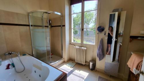 Exclusif - Splendide villa 6ch à 15min de Lyon في ريليوكس: امرأة تقف في الحمام مع حوض استحمام ودش