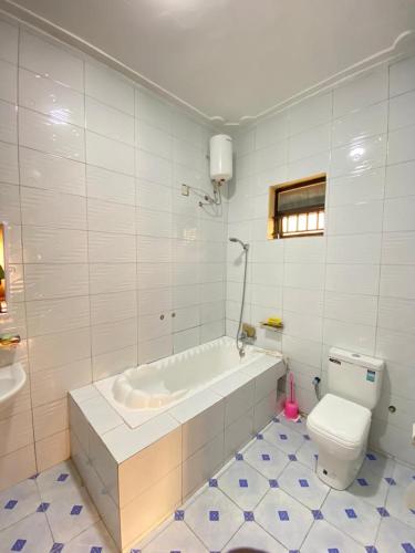 ein weißes Bad mit einer Badewanne und einem WC in der Unterkunft Viola in Kampala