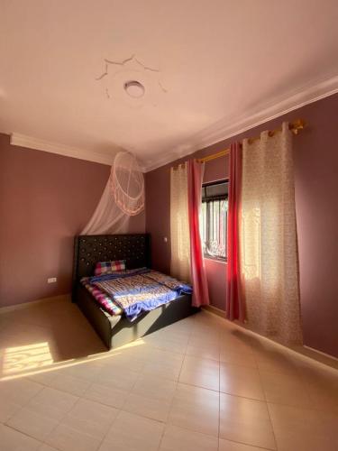 ein Schlafzimmer mit einem Bett in der Ecke eines Zimmers in der Unterkunft Viola in Kampala