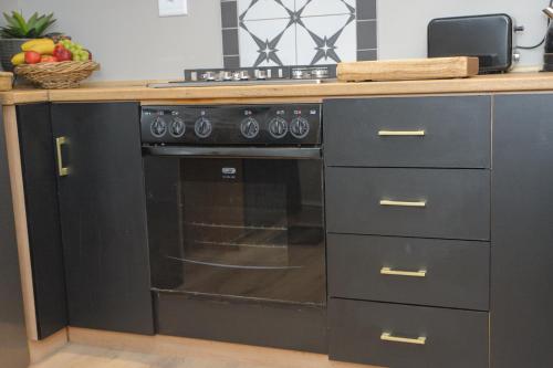 a black oven in a kitchen with a counter at Royal Pearl, Insta-worthy APT in Paarl