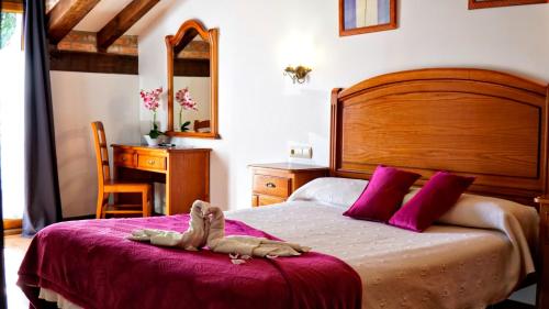 a stuffed animal laying on a bed in a bedroom at Hotel Marfrei in Hinojedo