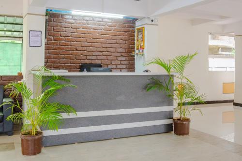 a lobby with a brick wall and two plants at Itsy By Treebo - Opal Suites in Pune