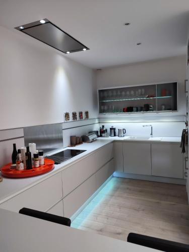 eine Küche mit weißen Schränken und einem Waschbecken in der Unterkunft Appartement au Grau du roi in Le Grau-du-Roi
