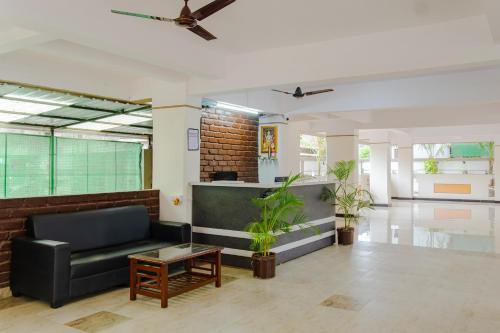 - un hall avec un canapé noir et des plantes dans l'établissement Itsy By Treebo - Opal Suites, à Pune
