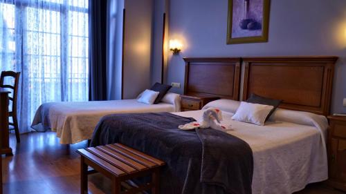 a hotel room with two beds with a stuffed animal on the bed at Hotel Marfrei in Hinojedo