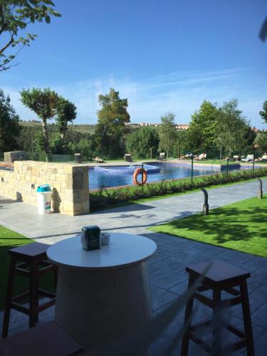 a patio with a table and two chairs and a pool at Hotel Marfrei in Hinojedo