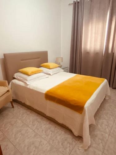 a bedroom with a large bed with yellow pillows at Apartamento Siomaly - Piscina in Praia