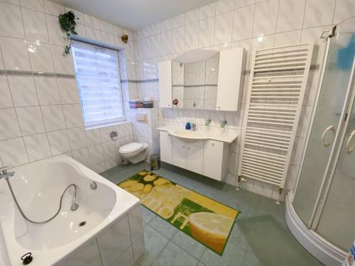 a bathroom with a tub and a sink and a toilet at Ferienwohnung im Kranichgebiet in Groß Mohrdorf