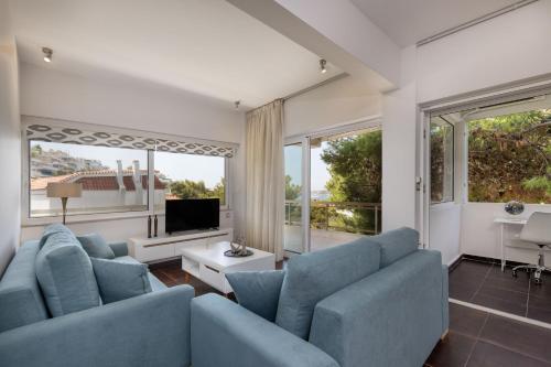 a living room with blue furniture and large windows at Relux Sea View 2BD Apartment by BluPine in Athens