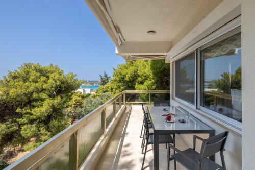 a patio with a table and chairs on a balcony at Relux Sea View 2BD Apartment by BluPine in Athens