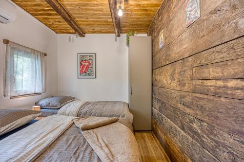 two beds in a room with a large wooden wall at Holiday Home Carpe Diem in Jastrebarsko