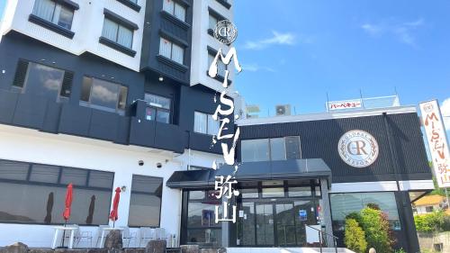 un edificio con letreros chinos colgando de él en Global Resort Misen - グローバルリゾート弥山, en Hatsukaichi