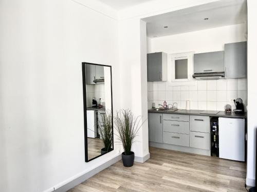 - une cuisine avec des placards blancs et un miroir dans la chambre dans l'établissement Studio Place Castellane, à Marseille