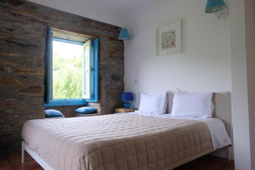 a bedroom with a large bed with a window at Casa do Engenho - Canadelo Amarante in Amarante