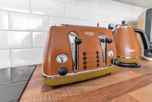 an orange toaster sitting on top of a kitchen counter at Weatherhead Lodge - Modern and Sleek Derby Apartment in Derby