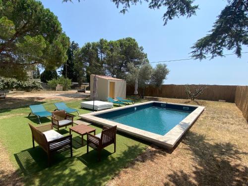 - une piscine dans une cour avec des chaises et une table dans l'établissement Le Cyprès de Casimir, à Beaucaire