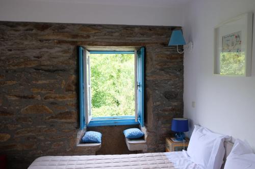 ein Schlafzimmer mit einem Fenster in einer Ziegelwand in der Unterkunft Casa do Engenho - Canadelo Amarante in Amarante