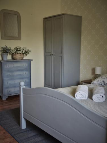 a bedroom with a bed with a dresser and towels at Agroturystyka u Świątków in Stara Kamienica