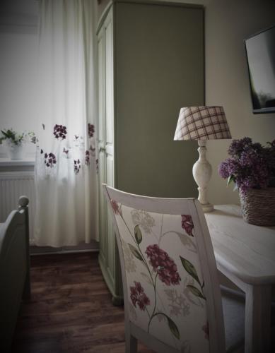 a room with a chair and a table with a lamp at Agroturystyka u Świątków in Stara Kamienica