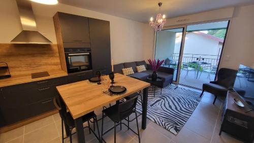 - une cuisine et une salle à manger avec une table en bois dans l'établissement LE REVEST Terrasse Vue Mer Centre Climatisation Parking, à Sète