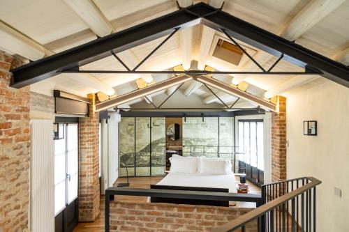 a bedroom in a loft with a bed in it at Palazzo Fauzone Relais in Mondovì