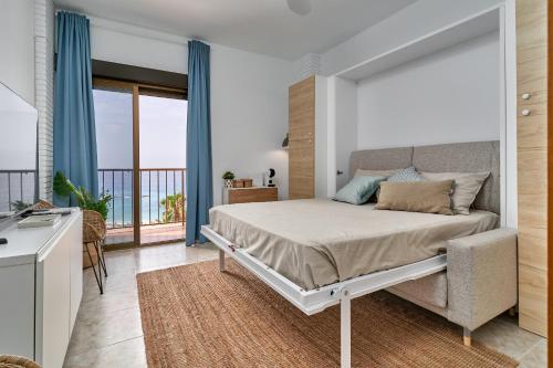 een slaapkamer met een bed en een balkon bij Estudio Puerta del Mar in Almuñécar