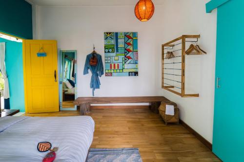 a bedroom with a bed and a yellow door at Ock Pop Tok Mekong Villa in Luang Prabang
