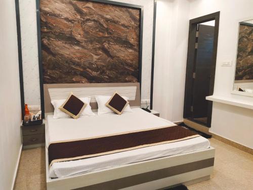 a bedroom with a bed with a large painting on the wall at Hotel The Shree Jee Palace in Mirzāpur
