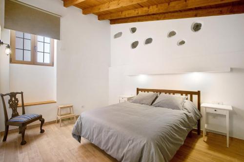 Casa Marhec في تاكورونتي: غرفة نوم بيضاء بسرير وكرسي