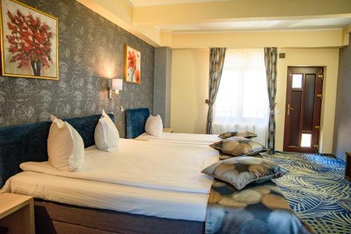a hotel room with two beds with pillows at Hotel Stefani in Sibiu