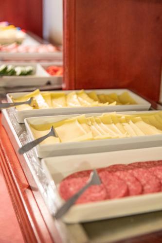 a buffet with cheese and meat and other foods at Hotel Kupolen in Borlänge