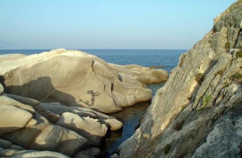 a painting of a goat on a rock next to the water at The Diamond of Kriaritsi "Villas with private pools & hydromassage" in Kriaritsi