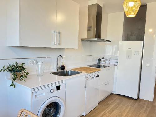 een witte keuken met een wasmachine en een koelkast bij CARIATIDES SKY APARTMENT in Zamora