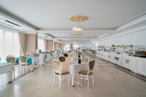 a dining room with white tables and chairs at SL La Perla Hotel Kemer in Antalya