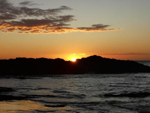 a sunset over a island in the ocean at MILLET'S FOOD COMPANY AND COOKING CENTER in Negombo