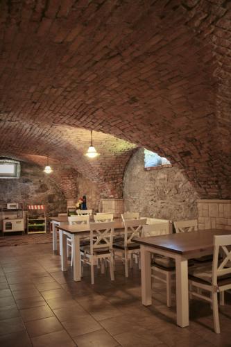 a dining room with tables and chairs and a brick wall at Agroturystyka u Świątków in Stara Kamienica