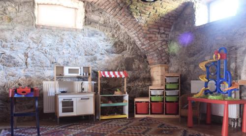 a room with a stone wall with a pretend kitchen at Agroturystyka u Świątków in Stara Kamienica