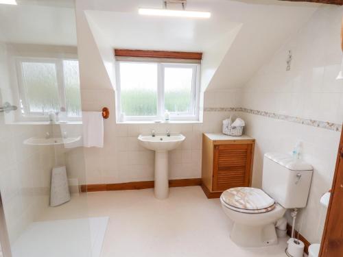 a white bathroom with a toilet and a sink at 91 Main Street in Frodsham