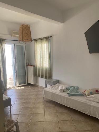 a bedroom with a bed and a large window at MARGARITA STUDIOS in Antiparos