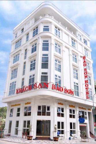 a large white building with a red sign on it at Bảo Sơn Hotel in Ha Long