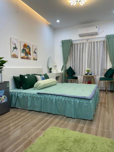 a bedroom with a bed with a green bedspread at Nhà Nghỉ Huyền Anh in Hanoi