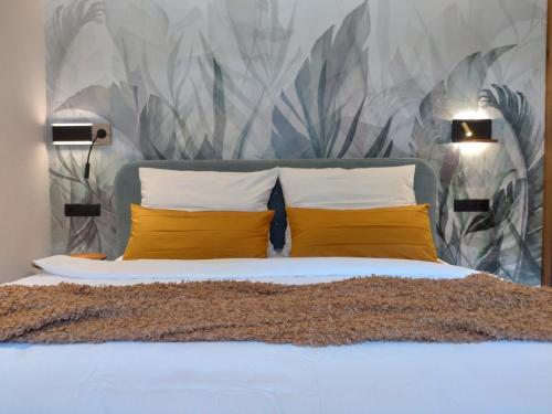 a bedroom with a bed with two yellow pillows at Aenna Apart Prutz in Prutz