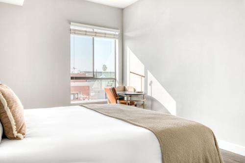 ロサンゼルスにあるNorth Hollywood 2br w pool gym prime NoHo LAX-921のベッドとテーブルと窓のある寝室