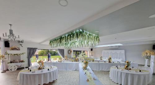 un salón de banquetes con mesas blancas con flores. en The Whitehouse Peterlee, en Peterlee