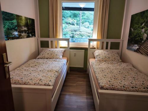 - 2 lits dans une petite chambre avec fenêtre dans l'établissement Apartement Wald-Panorama Fuchsenstein, à Spiegelau
