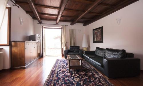 a living room with a black couch and a table at Casa Vacanza Piantamori in Cerreto di Spoleto