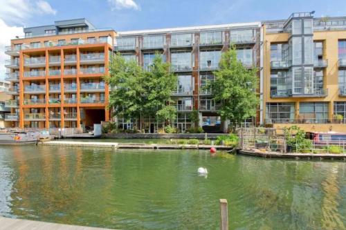 a large building next to a body of water at Incredible 2BD Loft by Regents Canal - Haggerston in London